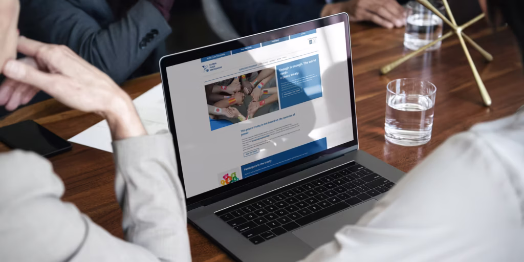 Laptop auf einem Konferenztisch zeigt die Startseite der GPP Webseite